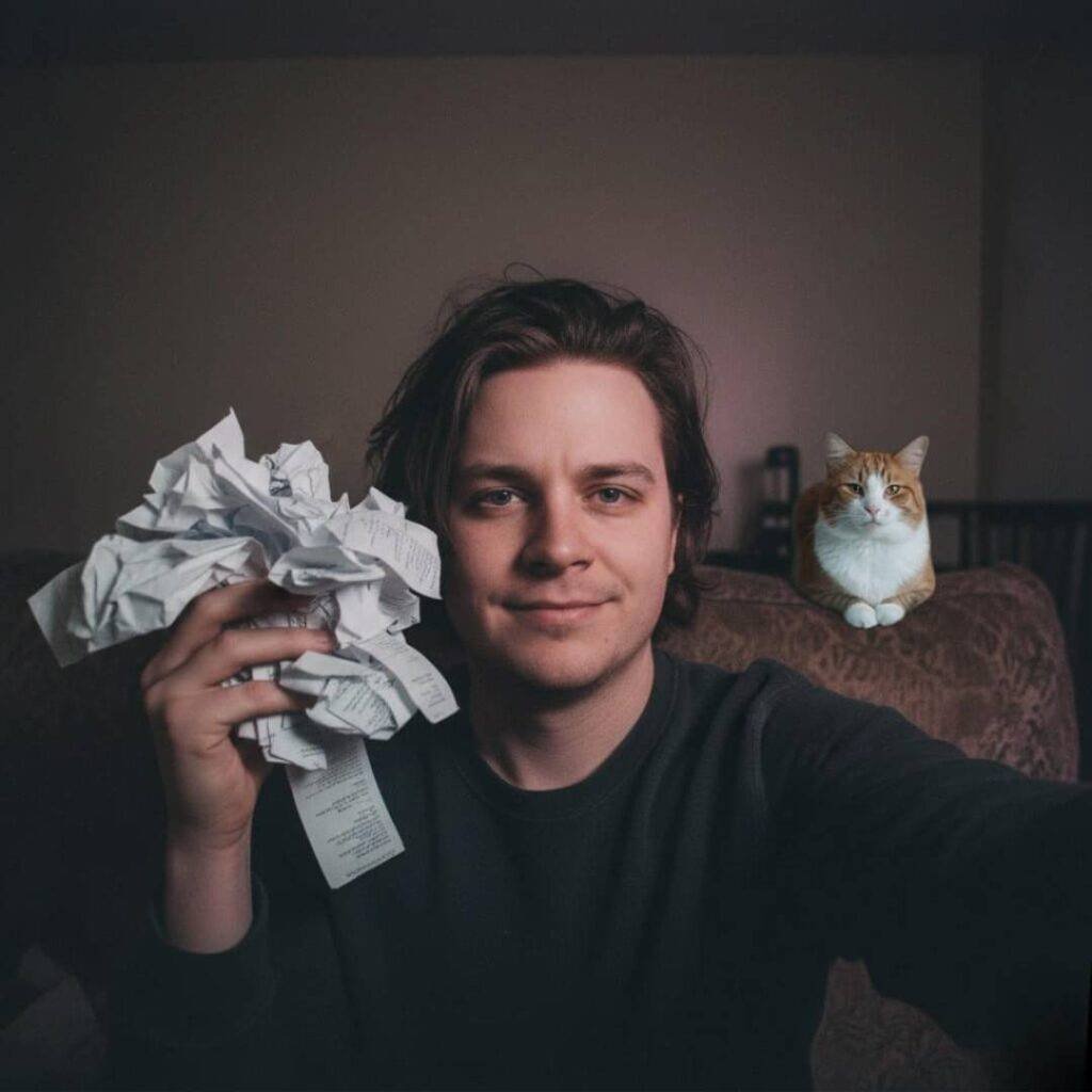 A raw selfie of a person holding crumpled receipts and smirking, with a cat named Pickles glaring from the couch in the background.